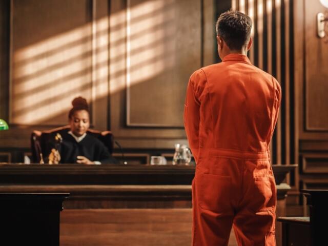 An inmate stands before a judge.