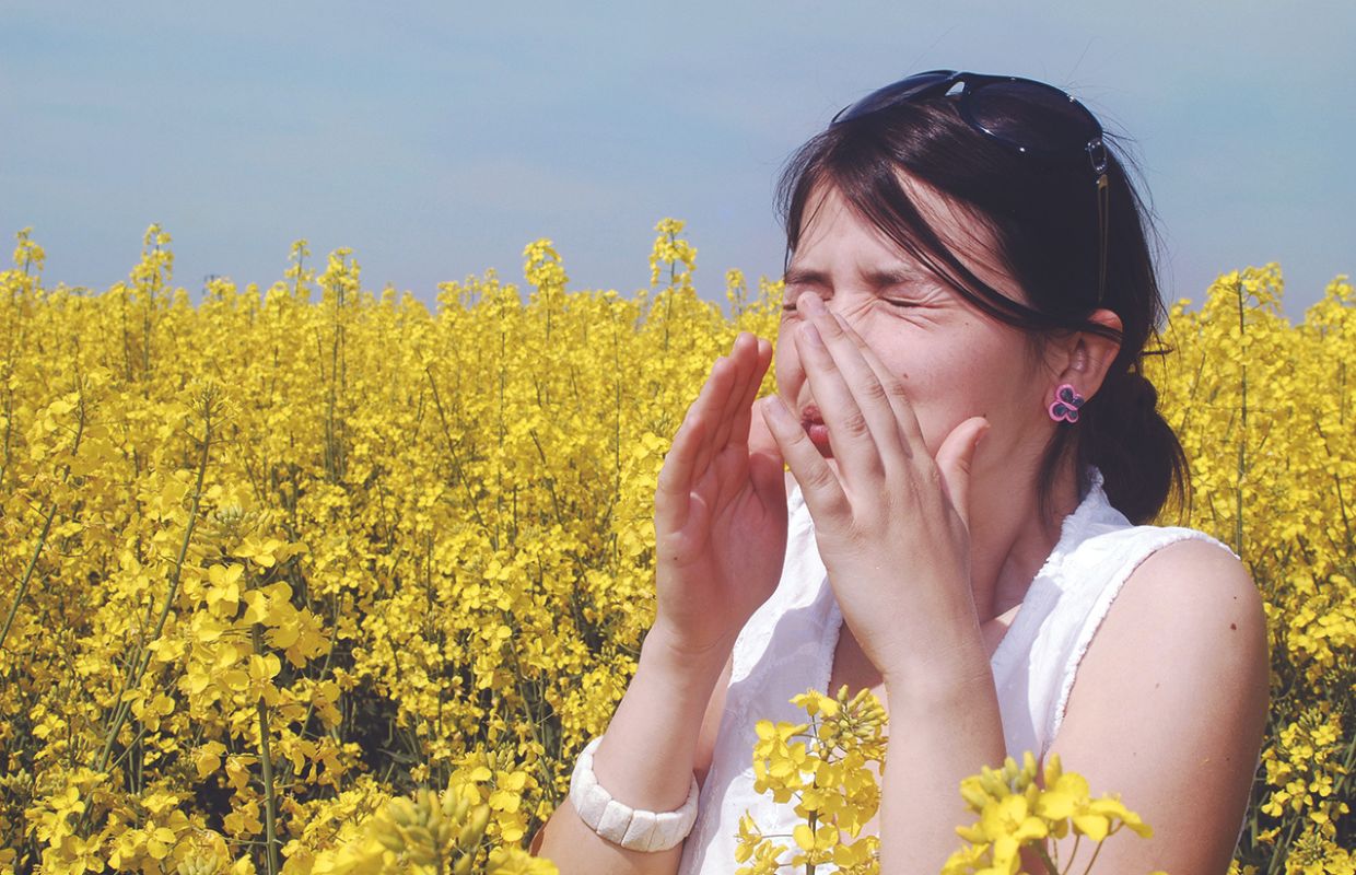 Woman sneezing in field