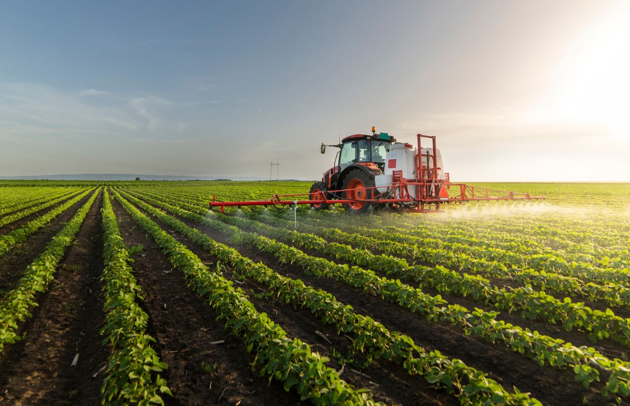 Farmer sprays pesticide on soybean field