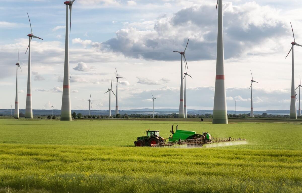 Farmer in field with wind turbines on property