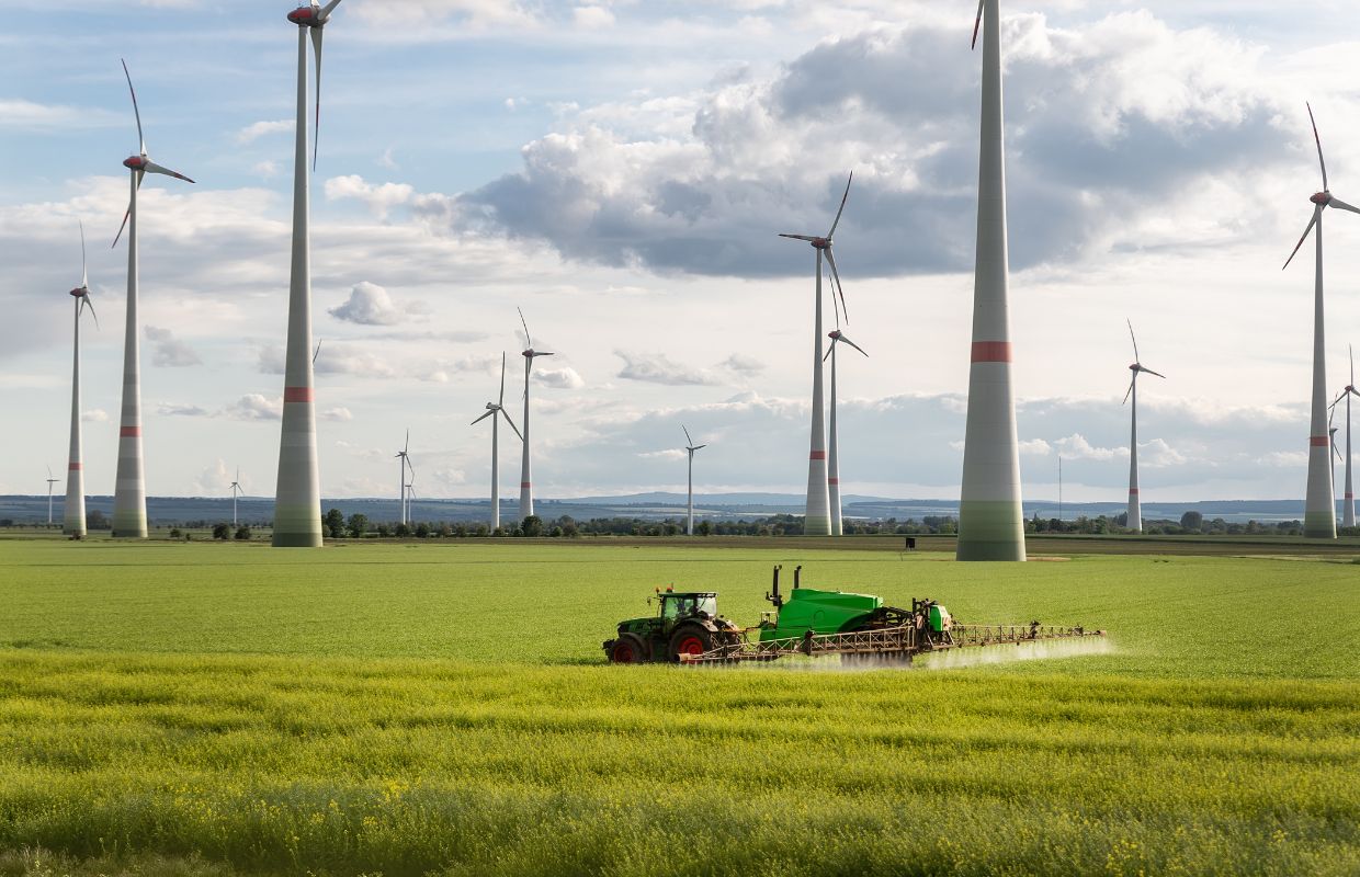 Farmer in field with wind turbines on property