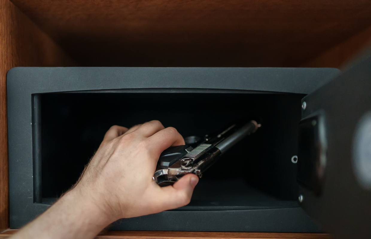 Man putting gun in safe