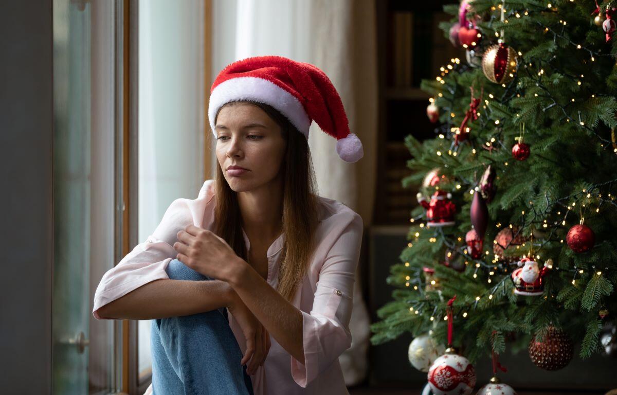 Sad woman next to Christmas tree