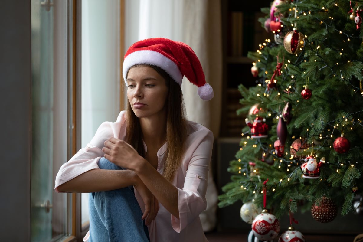 Sad woman next to Christmas tree