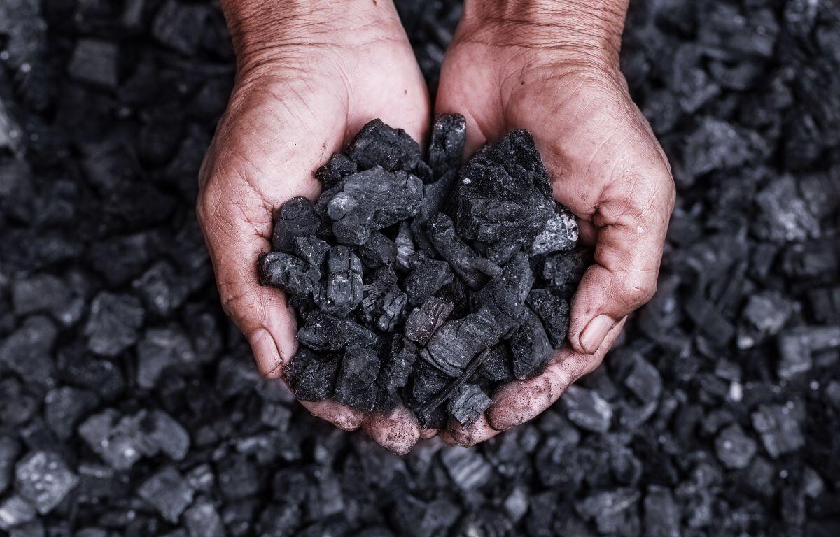 Coal miner with coal in hands