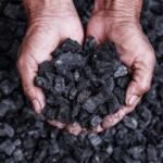 Coal miner with coal in hands