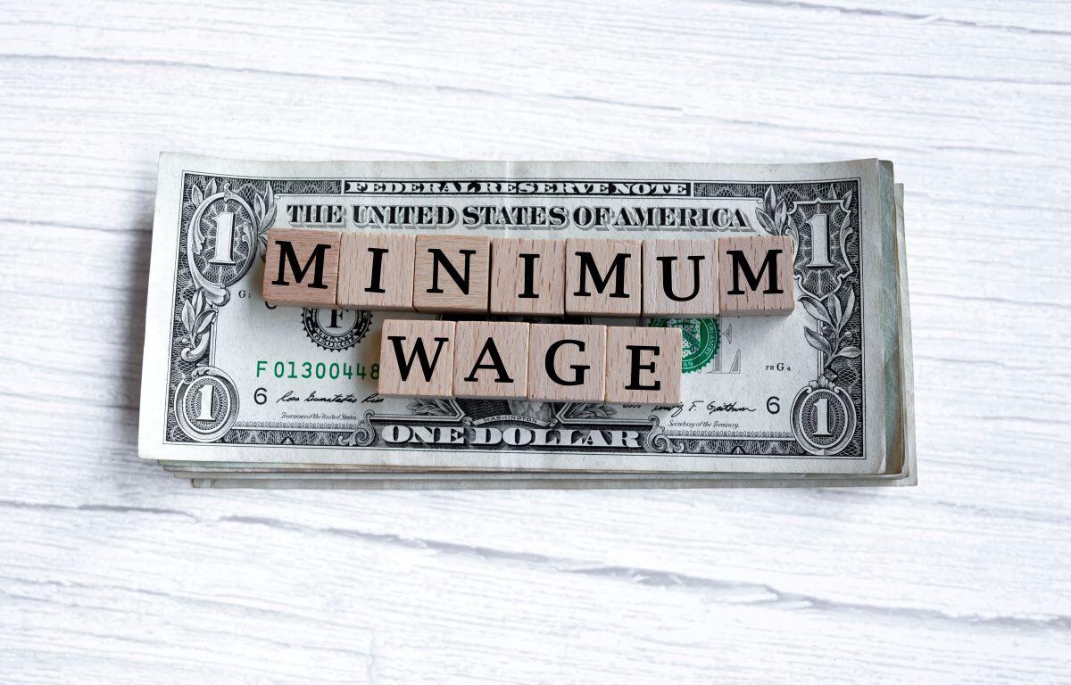 Minimum wage in letters on dollar bills