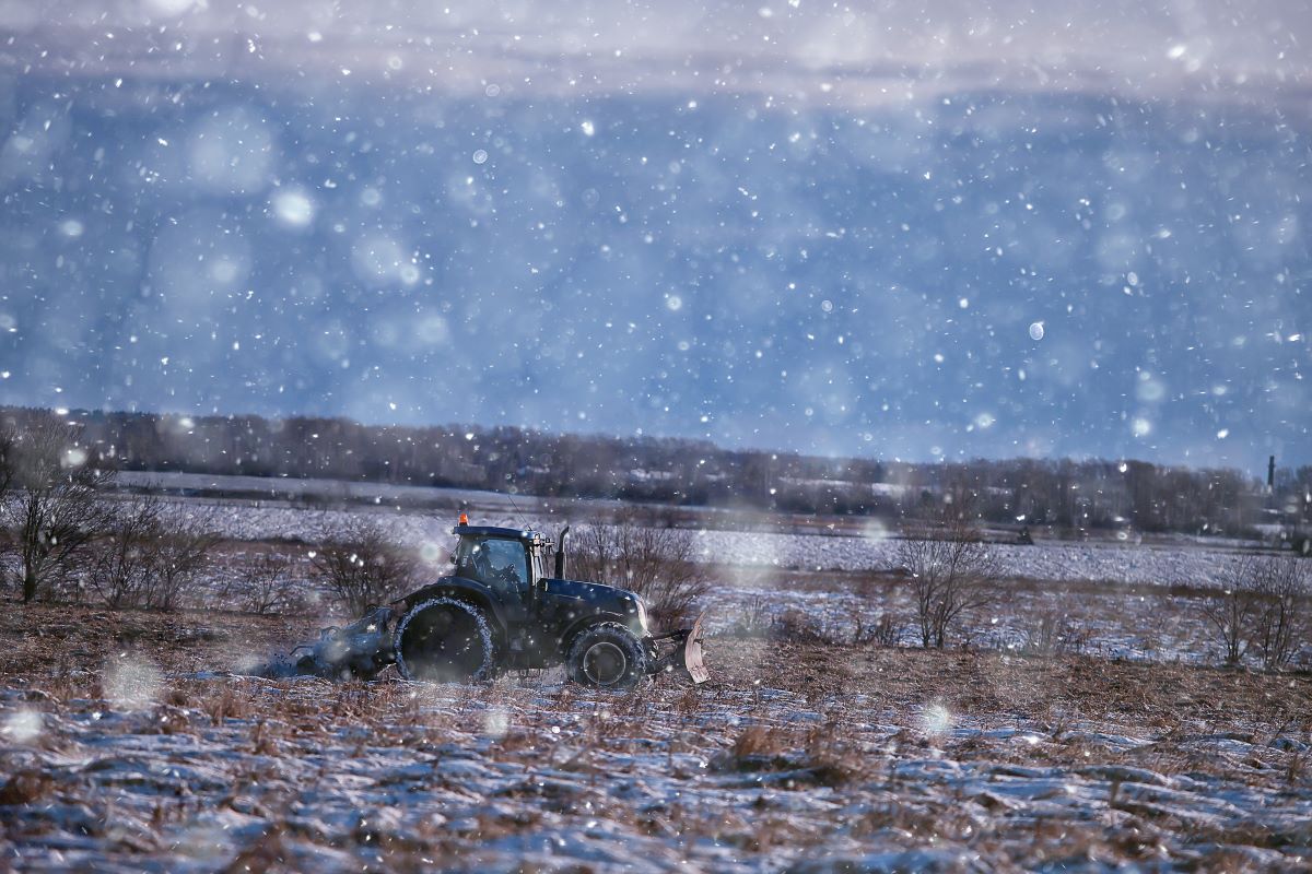 Farmer in field in tractor during winter weather