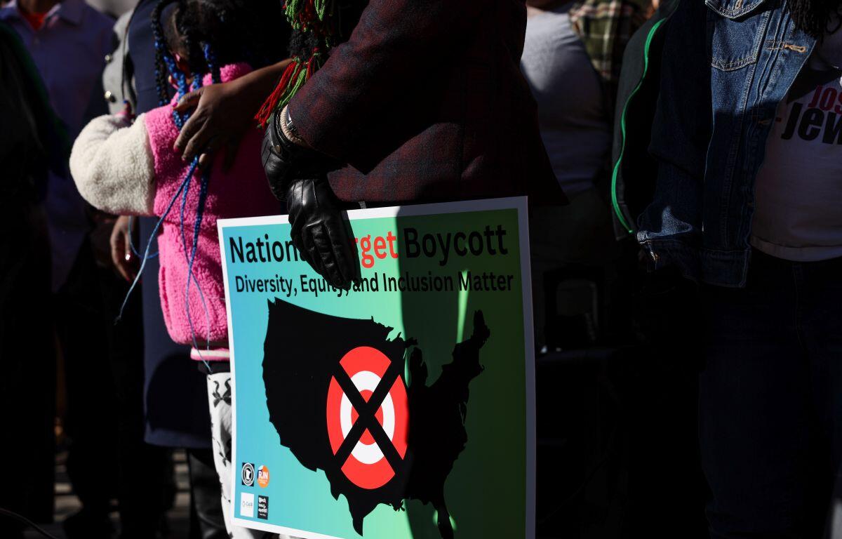 A community member holds a sign calling for a national boycott of Target stores during a news conference outside Target Corporation's headquarters Thursday, Jan. 30, 2025, in Minneapolis, Minn. (AP Photo/Ellen Schmidt, File)