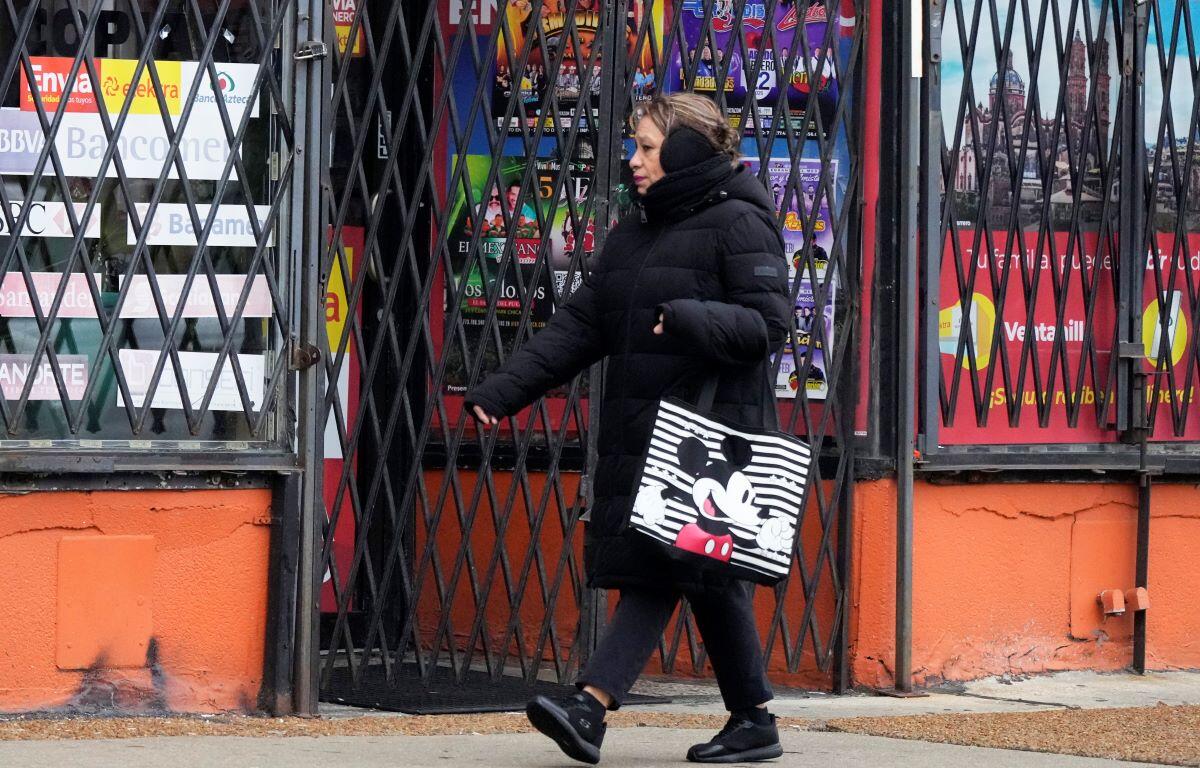 A pedestrian passes a closed store in the Little Village neighborhood of Chicago, Monday, Feb. 3, 2025. (AP Photo/Nam Y. Huh)