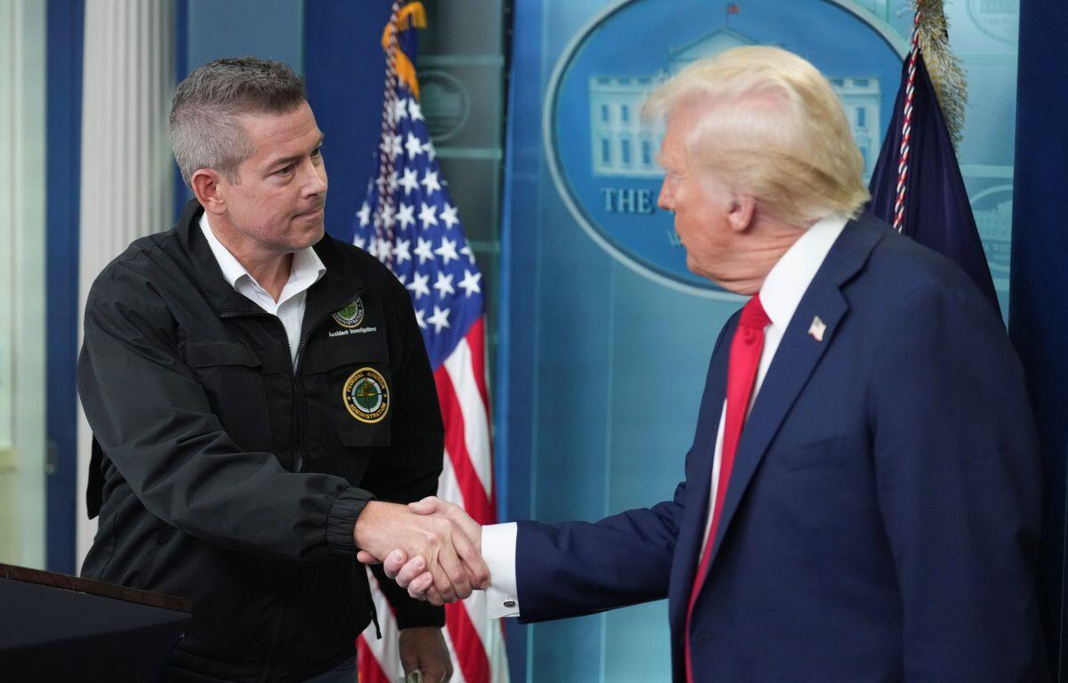 President Donald Trump shakes hands with Transportation Secretary Sean Duffy in the James Brady Press Briefing Room at the White House, Thursday, Jan. 30, 2025, in Washington. (AP Photo/Jacquelyn Martin)