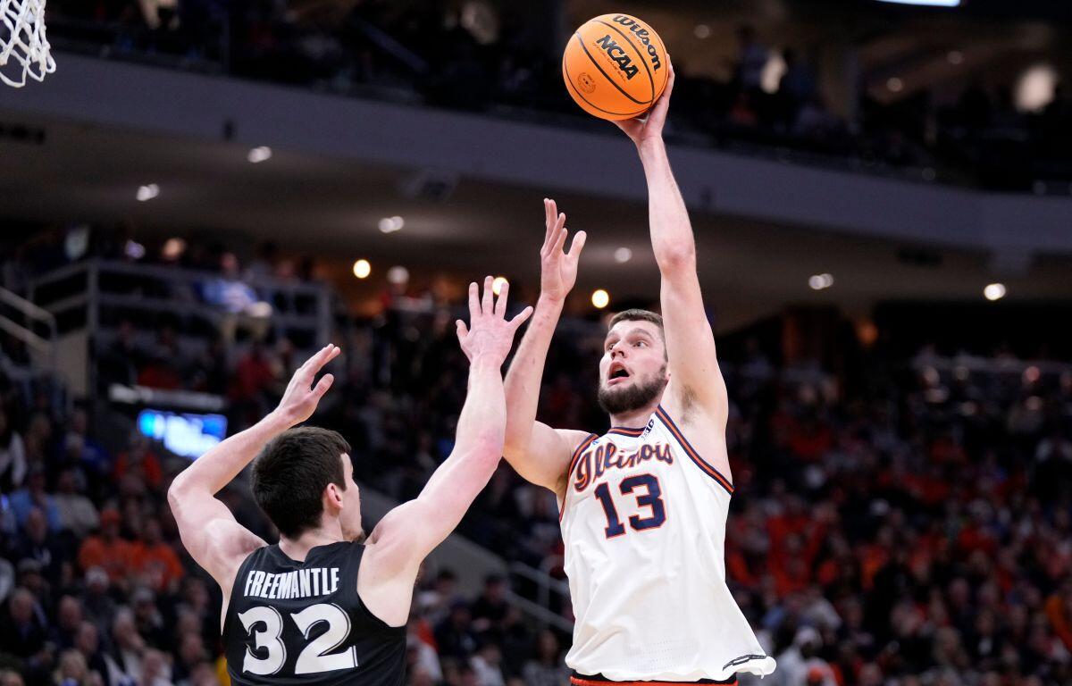 Illinois center Tomislav Ivisic (13) scores against Xavier forward Zach Freemantle (32) during the first half in the first round of the NCAA college basketball tournament, Friday, March 21, 2025, in Milwaukee. (AP Photo/Kayla Wolf)