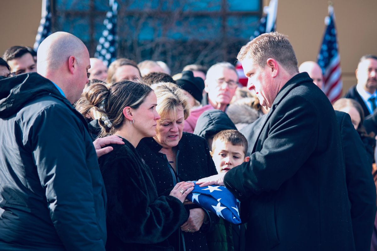 Illinois State Police Director Brendan Kelly hands a flag to Meghan Carns, the widow of Trooper Clay Carns, who died on Dec. 23, 2024. John Fleet, 69, of Wilmington, was charged with violating Scott's Law, which is a Class 4 Felony. (Photo provided)