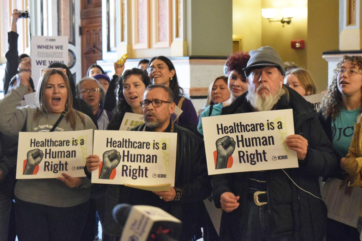 A crowd gathers at the Illinois Capitol in February to urge state lawmakers to continue to support pro-immigrant policies, including Illinois’ programs for noncitizen health care. Gov. JB Pritzker’s administration has proposed cutting one of the programs. (Capitol News Illinois photo by Jade Aubrey)