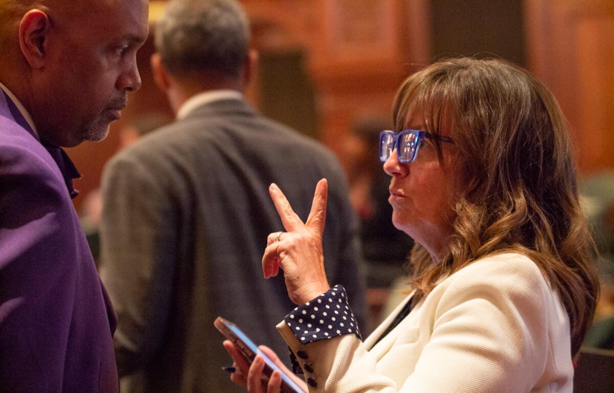 State Rep. Katie Stuart, D-Edwardsville, speaks to chief of staff Clayton Harris shortly after passing a bill that mandates employers give nursing mothers paid time to pump breast milk. (Capitol News Illinois photo by Jerry Nowicki)