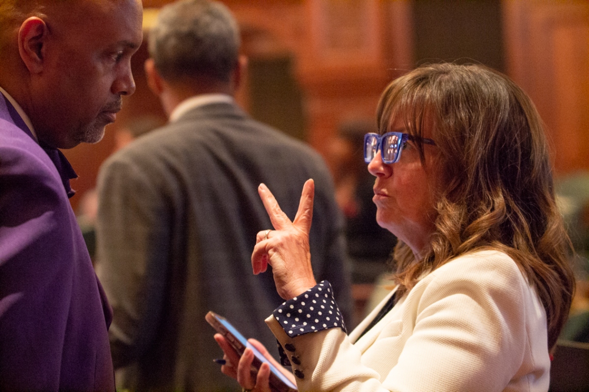 State Rep. Katie Stuart, D-Edwardsville, speaks to chief of staff Clayton Harris shortly after passing a bill that mandates employers give nursing mothers paid time to pump breast milk. (Capitol News Illinois photo by Jerry Nowicki)