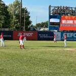 Springfield Lucky Horseshoes players warm up in the outfield on a hot day.