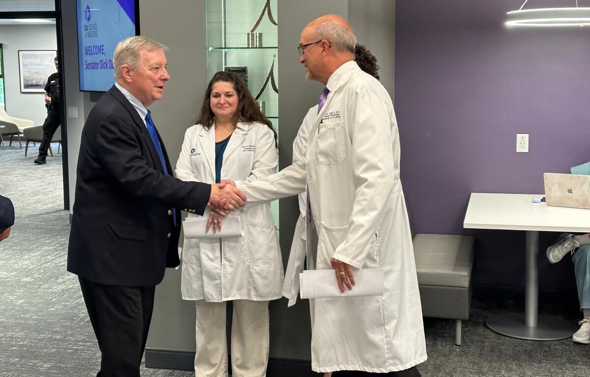 Sen. Duck Durbin (D-IL) shakes the hand of Dr. Don Torry, Dean of Research at SIU School of Medicine, as other administrators look on.