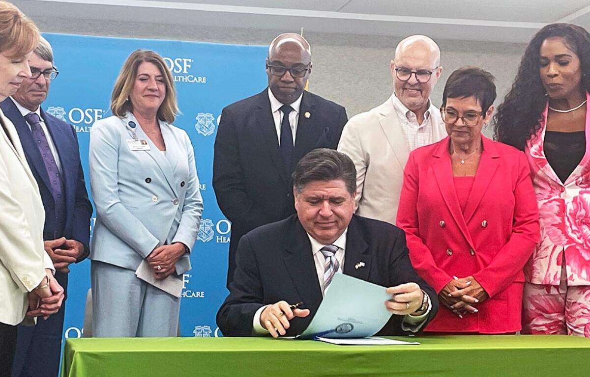 Gov. JB Pritzker signs two bills related to health care costs at a hospital in Peoria, including a bill that puts more controls on pharmacy benefit managers. (Capitol News Illinois photo by Andrew Campbell)