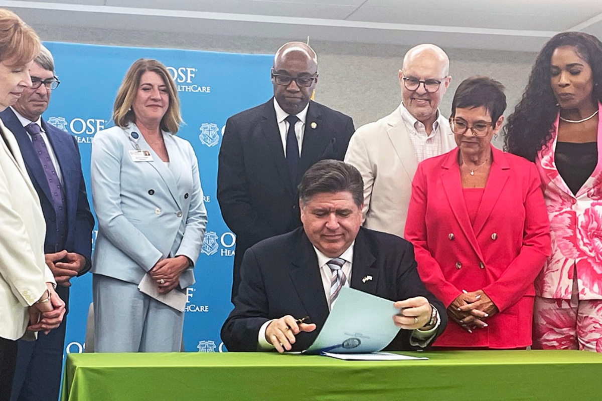 Gov. JB Pritzker signs two bills related to health care costs at a hospital in Peoria, including a bill that puts more controls on pharmacy benefit managers. (Capitol News Illinois photo by Andrew Campbell)