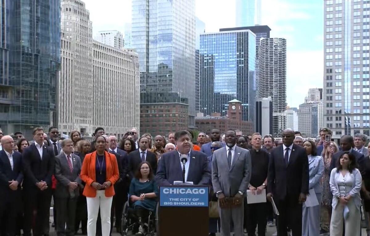 Governor JB Pritzker, surrounded by local and State of Illinois political leaders, speaks Monday afternoon in Chicago.