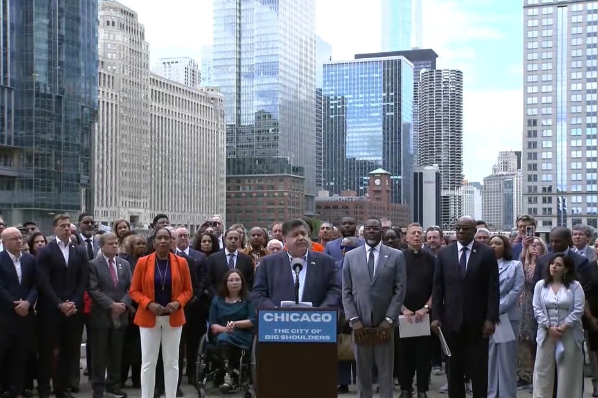 Governor JB Pritzker, surrounded by local and State of Illinois political leaders, speaks Monday afternoon in Chicago.
