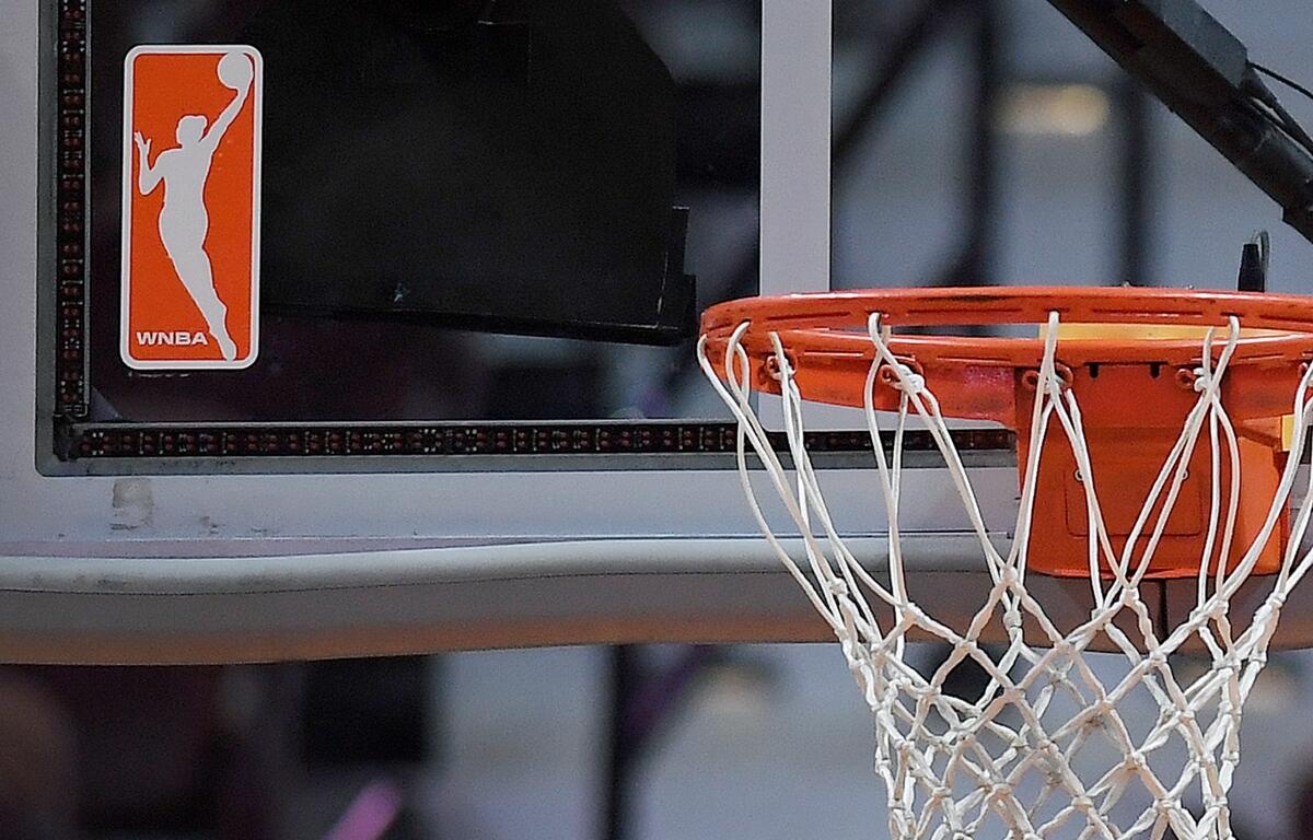 FILE - The WNBA logo is seen near a hoop before an WNBA basketball game at Mohegan Sun Arena, Tuesday, May 14, 2019, in Uncasville, Conn. (AP Photo/Jessica Hill, File)