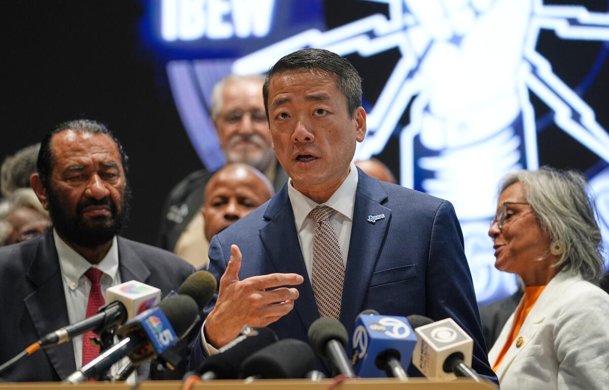 Democratic Texas Rep. Gene Wu, center, surrounded by other Texas House Democrats and Democratic members of Congress, speaks during a press conference at the Democratic Party in Warrenville, Ill., Monday, Aug. 4, 2025. (AP Photo/Nam Y. Huh)