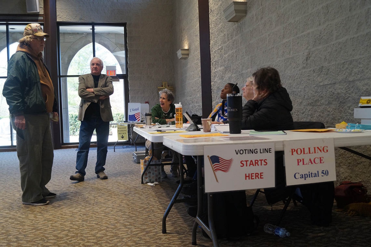 Election workers check voters’ names against a registration list and hand out ballots at a polling place in Springfield. (Capitol News Illinois file photo by Peter Hancock)