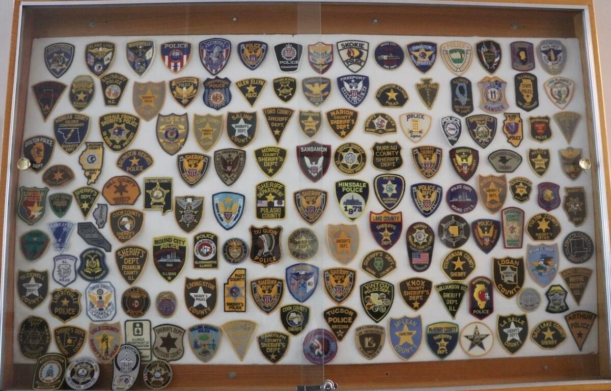 Law enforcement badges from sheriff and police departments across the state and the U.S. are displayed on a wall in the Pulaski County Courthouse. (Medill Illinois News Bureau photo by Maggie Dougherty)
