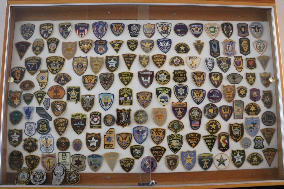 Law enforcement badges from sheriff and police departments across the state and the U.S. are displayed on a wall in the Pulaski County Courthouse. (Medill Illinois News Bureau photo by Maggie Dougherty)