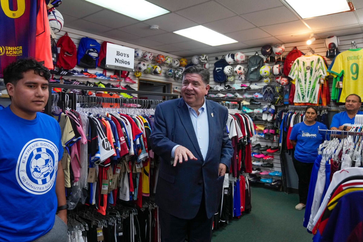 Illinois Gov. J.B. Pritzker visits with members of the family-owned soccer gear business Extreme Soccer, Thursday, Sept. 4, 2025, in Berwyn, Ill. (AP Photo/Erin Hooley)
