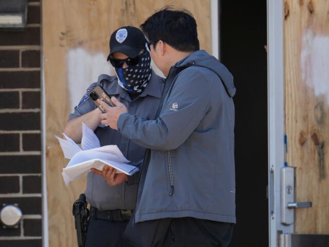 A person talks to a masked guard at the entrance of an immigration processing center Monday, Sept. 8, 2025, in Broadview, Ill., a suburb of Chicago. (AP Photo/Carolyn Kaster)