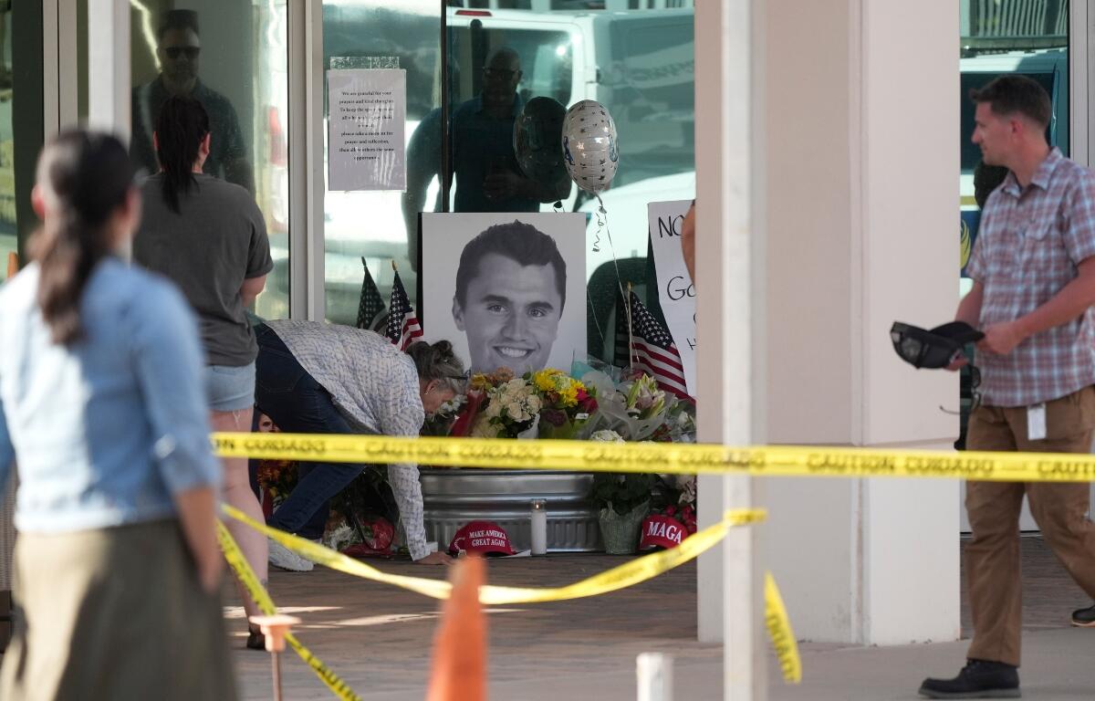 Well-wishers pay their respects at a makeshift memorial at the national headquarters of Turning Point USA after the shooting death of Charlie Kirk, CEO of the organization, during a Utah college event Wednesday, Sept. 10, 2025, in Phoenix. (AP Photo/Ross D. Franklin)