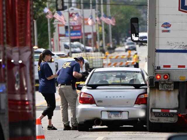 Investigators from the FBI survey the scene where an Immigration and Customs Enforcement officer shot and killed a suspect after the suspect drove his car at the arresting officers, Friday, Sept. 12, 2025, in Franklin Park, Ill. (AP Photo/Paul Beaty)
