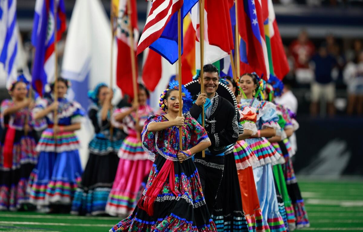 FILE - National flags from Latin American countries are displayed on the field during a celebration of Hispanic Heritage Month before an NFL football game between the Baltimore Ravens and Dallas Cowboys in Arlington, Texas, Sunday, Sept. 22, 2024. (AP Photo/Gareth Patterson, FILE)
