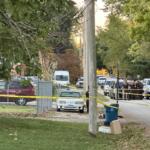 Crime scene tape and law enforcement vehicles are seen on Hoover Avenue October 9, the scene of a triple-homicide.