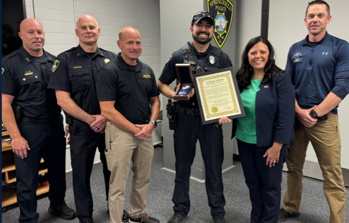 Officer Matthew Torres receives an award from Springfield Mayor Misty Buscher.