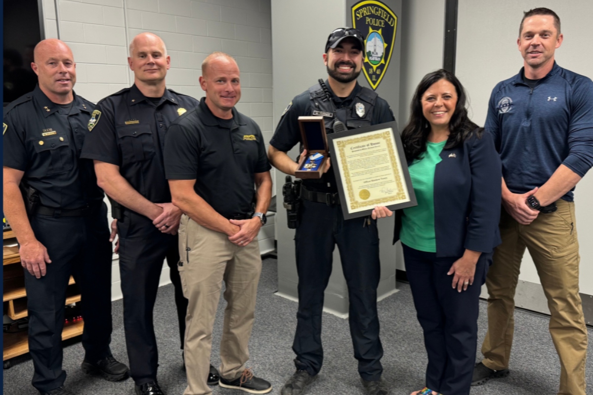 Officer Matthew Torres receives an award from Springfield Mayor Misty Buscher.