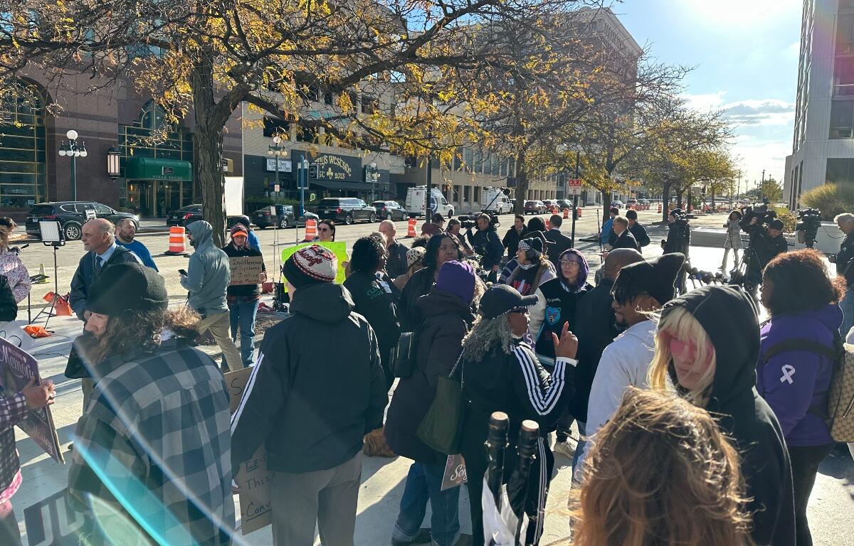 A crowd watches a news conference after the Sean Grayson trial verdict Wednesday in Peoria.