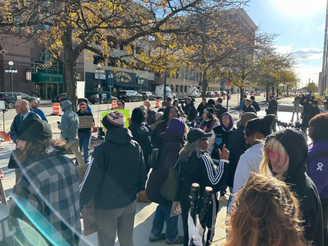 A crowd watches a news conference after the Sean Grayson trial verdict Wednesday in Peoria.