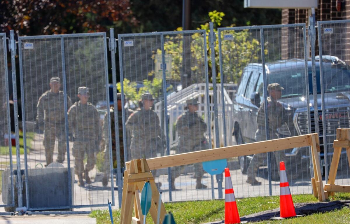 A group of people in military fatigues walks into an Immigration and Customs Enforcement facility in Broadview on Thursday, Oct. 9. National Guard troops were deployed to the facility earlier in the day. (Capitol News Illinois photo by Andrew Adams)