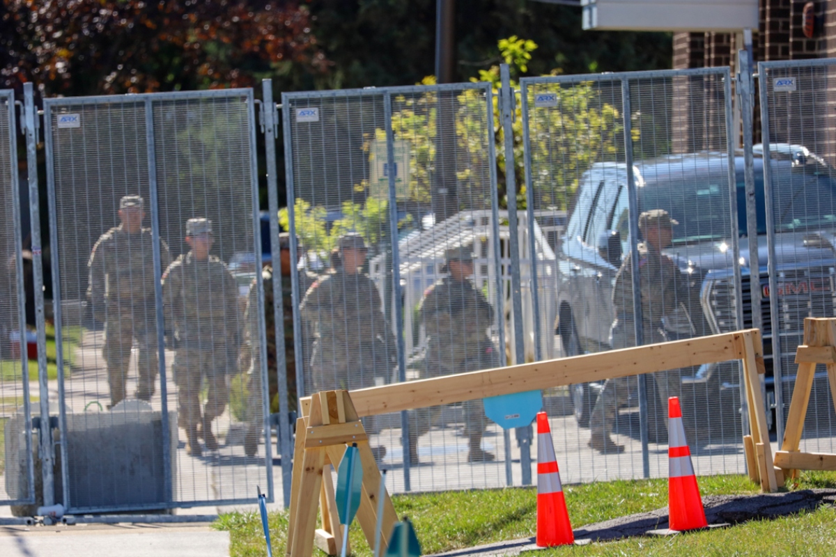 A group of people in military fatigues walks into an Immigration and Customs Enforcement facility in Broadview on Thursday, Oct. 9. National Guard troops were deployed to the facility earlier in the day. (Capitol News Illinois photo by Andrew Adams)