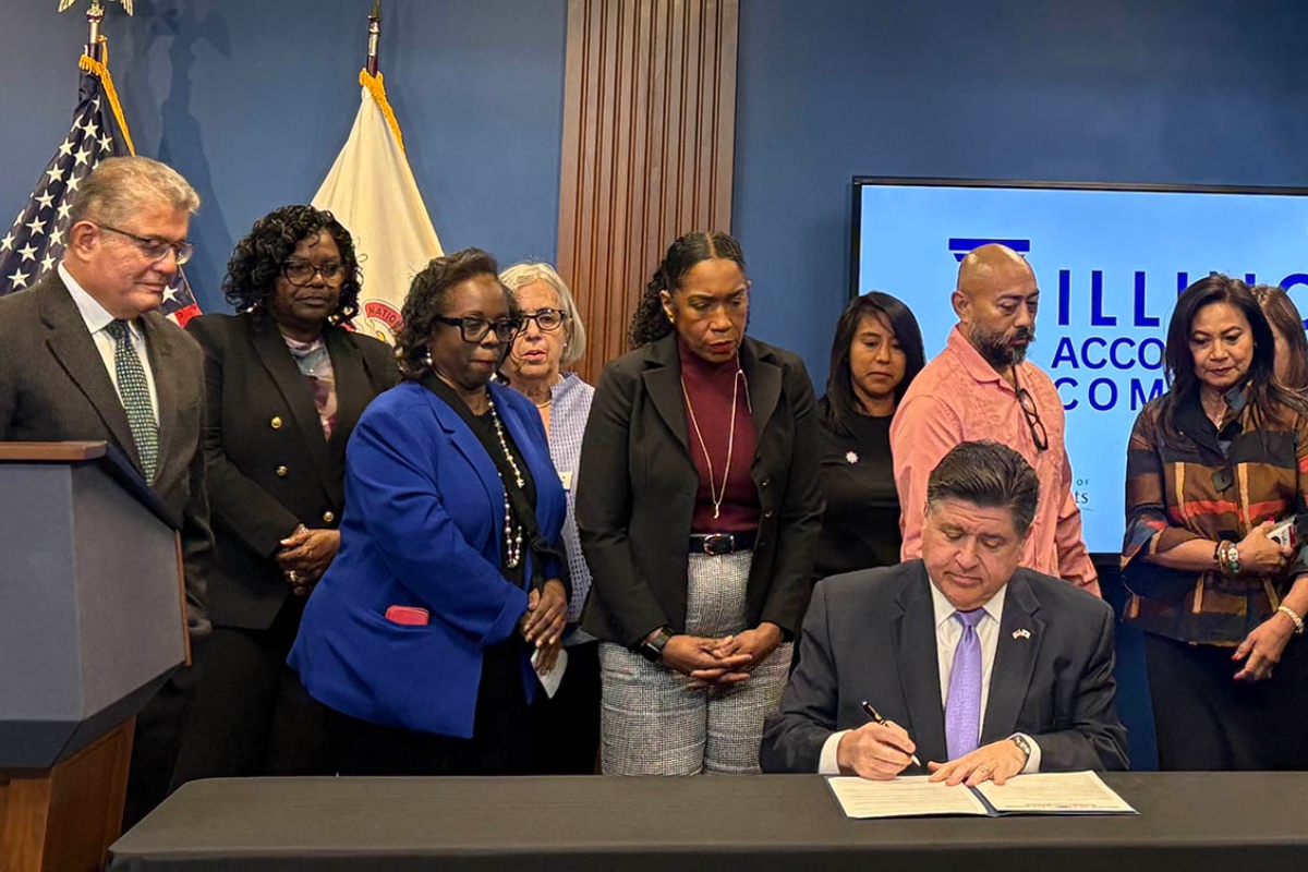 Gov. JB Pritzker signs an executive order in Chicago on Thursday, Oct. 23, creating the Illinois Accountability Commission to document abuses by federal agents. (Capitol News Illinois photo by Maggie Dougherty)
