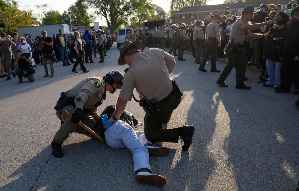 Law enforcement detains a protester near an Immigration and Customs Enforcement facility in Broadview, Ill., Friday, Oct. 3, 2025. (AP Photo/Erin Hooley)