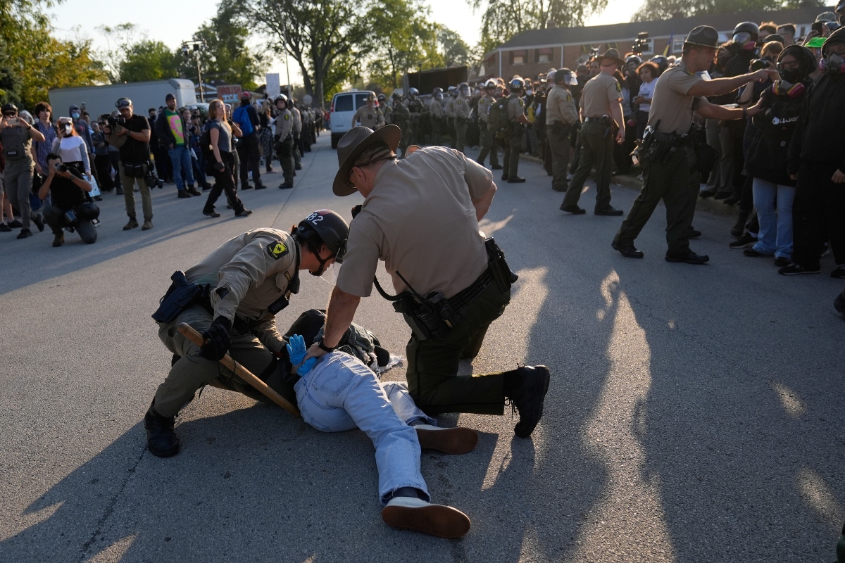 Law enforcement detains a protester near an Immigration and Customs Enforcement facility in Broadview, Ill., Friday, Oct. 3, 2025. (AP Photo/Erin Hooley)