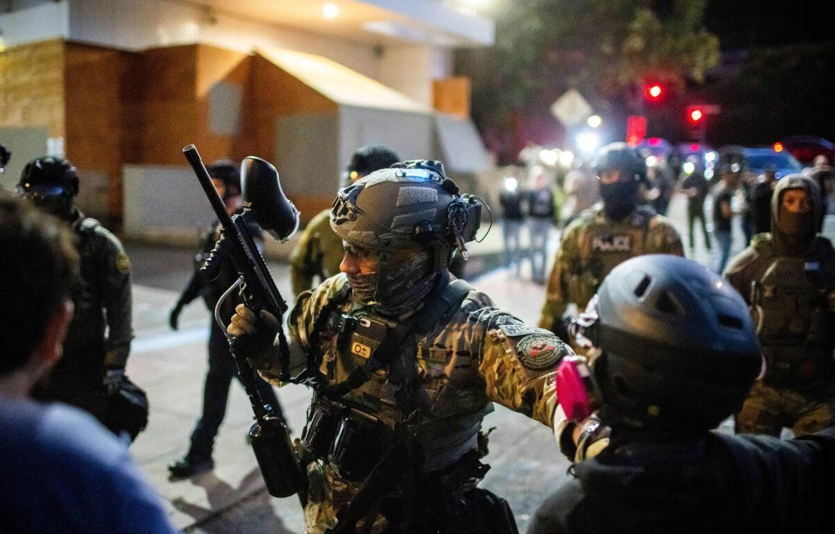 Police and Federal officers stand guard an area by the U.S. Immigration and Customs Enforcement facility in Portland, Ore. on Sunday, Oct. 5, 2025. (AP Photo/Ethan Swope)