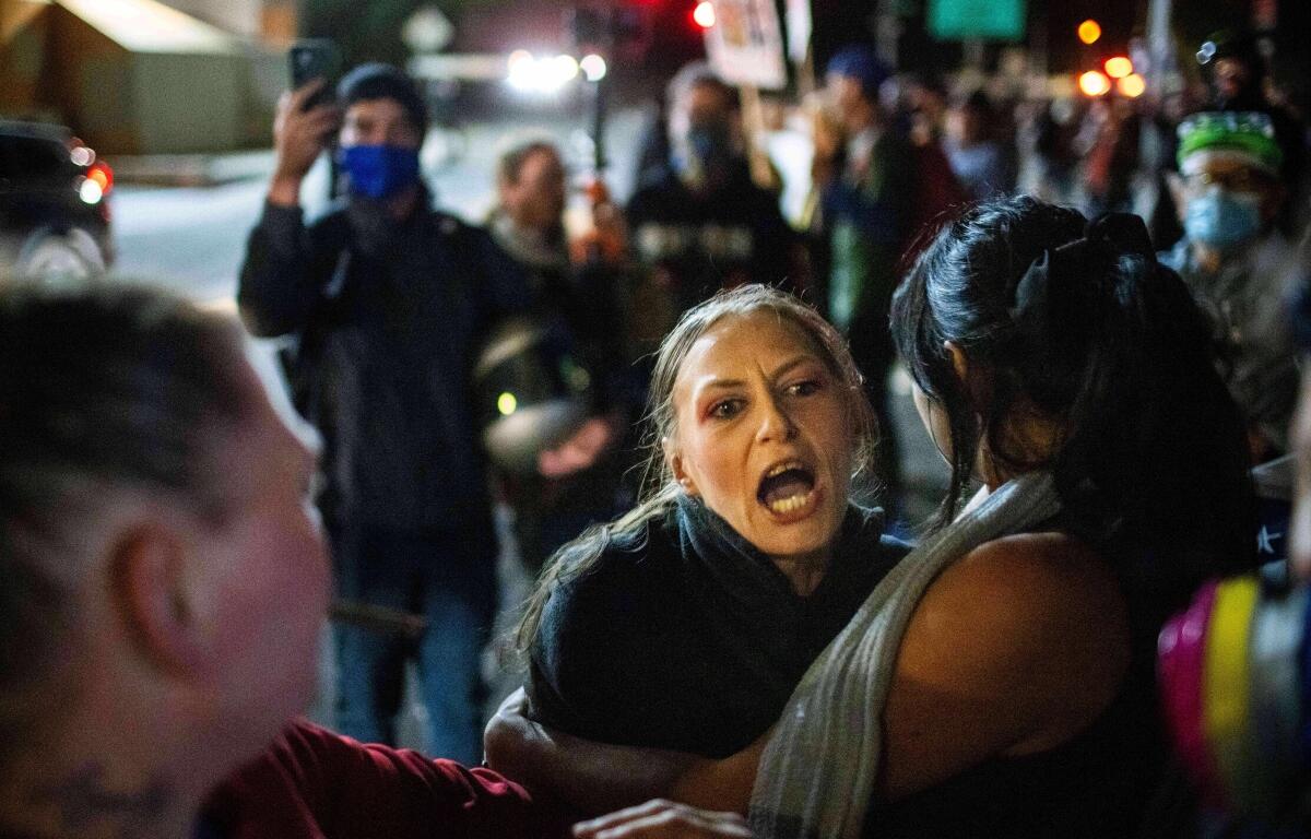 A protester yells at police and federal officers during a protest at a U.S. Immigration and Customs Enforcement facility in Portland, Ore. on Sunday, Oct. 5, 2025. (AP Photo/Ethan Swope)