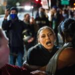 A protester yells at police and federal officers during a protest at a U.S. Immigration and Customs Enforcement facility in Portland, Ore. on Sunday, Oct. 5, 2025. (AP Photo/Ethan Swope)