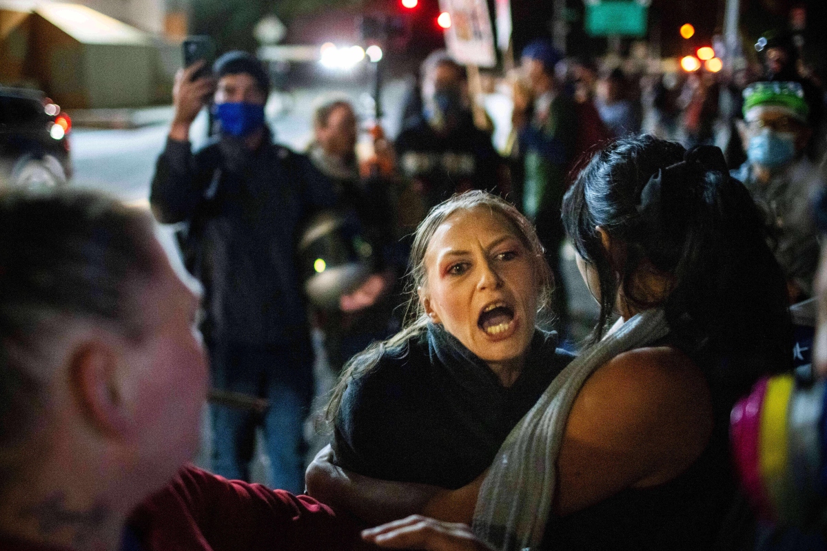 A protester yells at police and federal officers during a protest at a U.S. Immigration and Customs Enforcement facility in Portland, Ore. on Sunday, Oct. 5, 2025. (AP Photo/Ethan Swope)